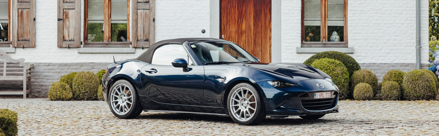 Blue car parked in front of house
