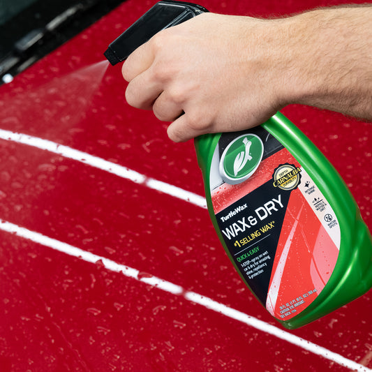 Turtle Wax being sprayed on a red car. Turtle Wax Wax & Dry gives a carnauba wax shine with lasting protection from water & dirt.