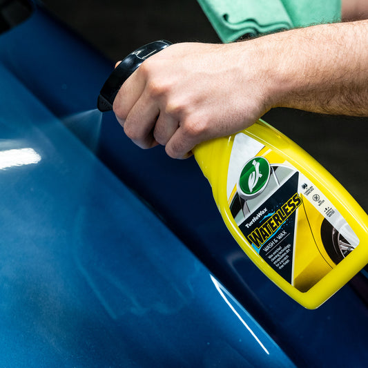 Turtle Wax waterless wash and wax being sprayed onto a blue car panel for a quick detail.