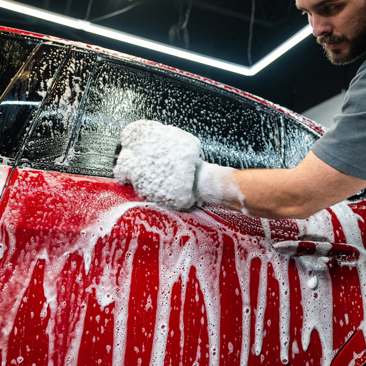 Cleaning a red car with Turtle Wax carnauba wash for a glossy, protected finish. Detailing service.
