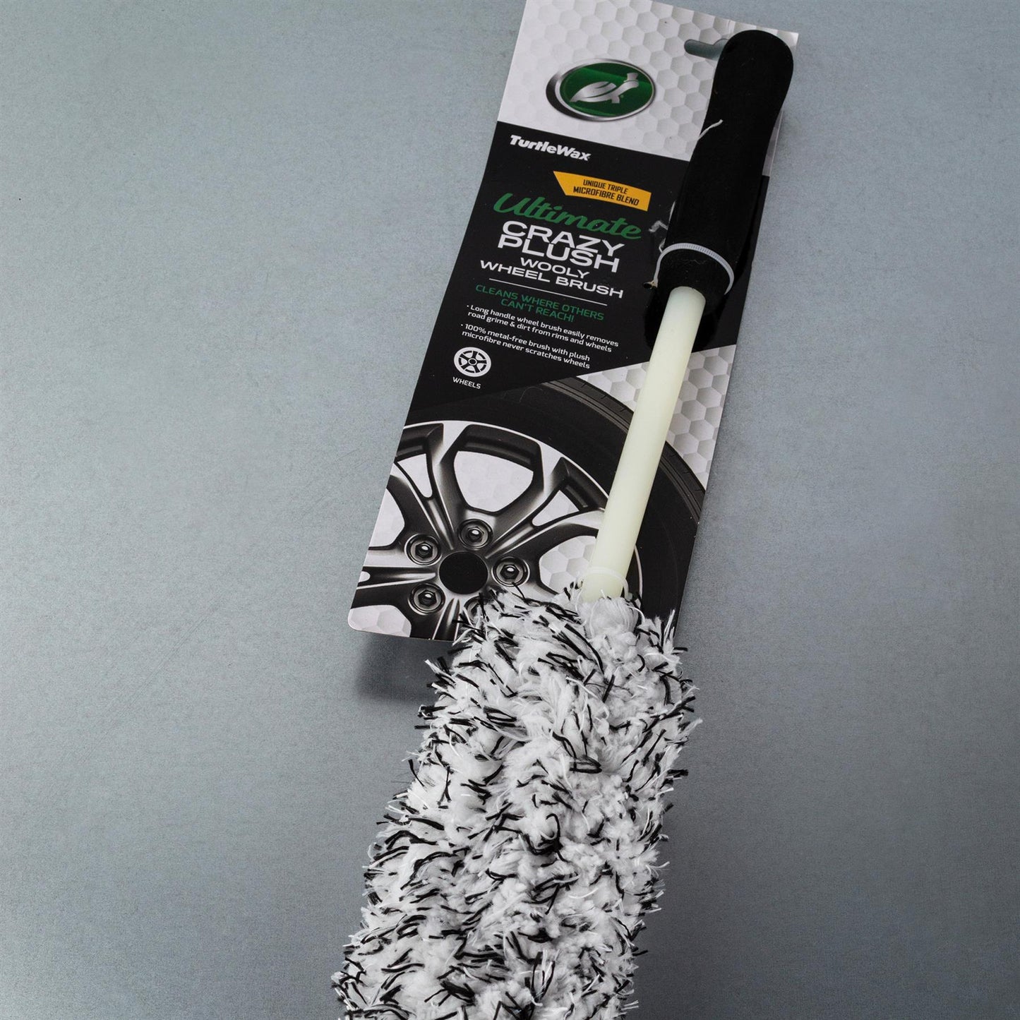 Fluffy car detailing brush. Soft, white wool with black accents and a long handle for reaching tight spaces.

