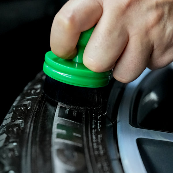 Applying tyre dressing with a round applicator. Green handle ensures grip for an even, streak-free finish on the tyre wall.