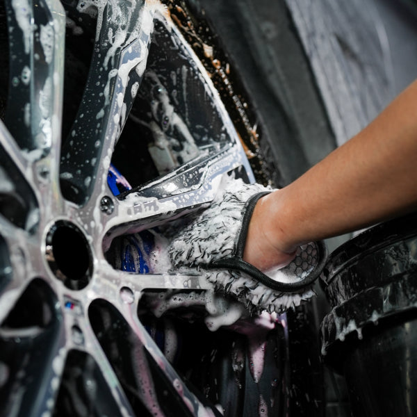 Car detailing: A microfibre wash mitt being used to clean alloy wheels. Car care and maintenance.
