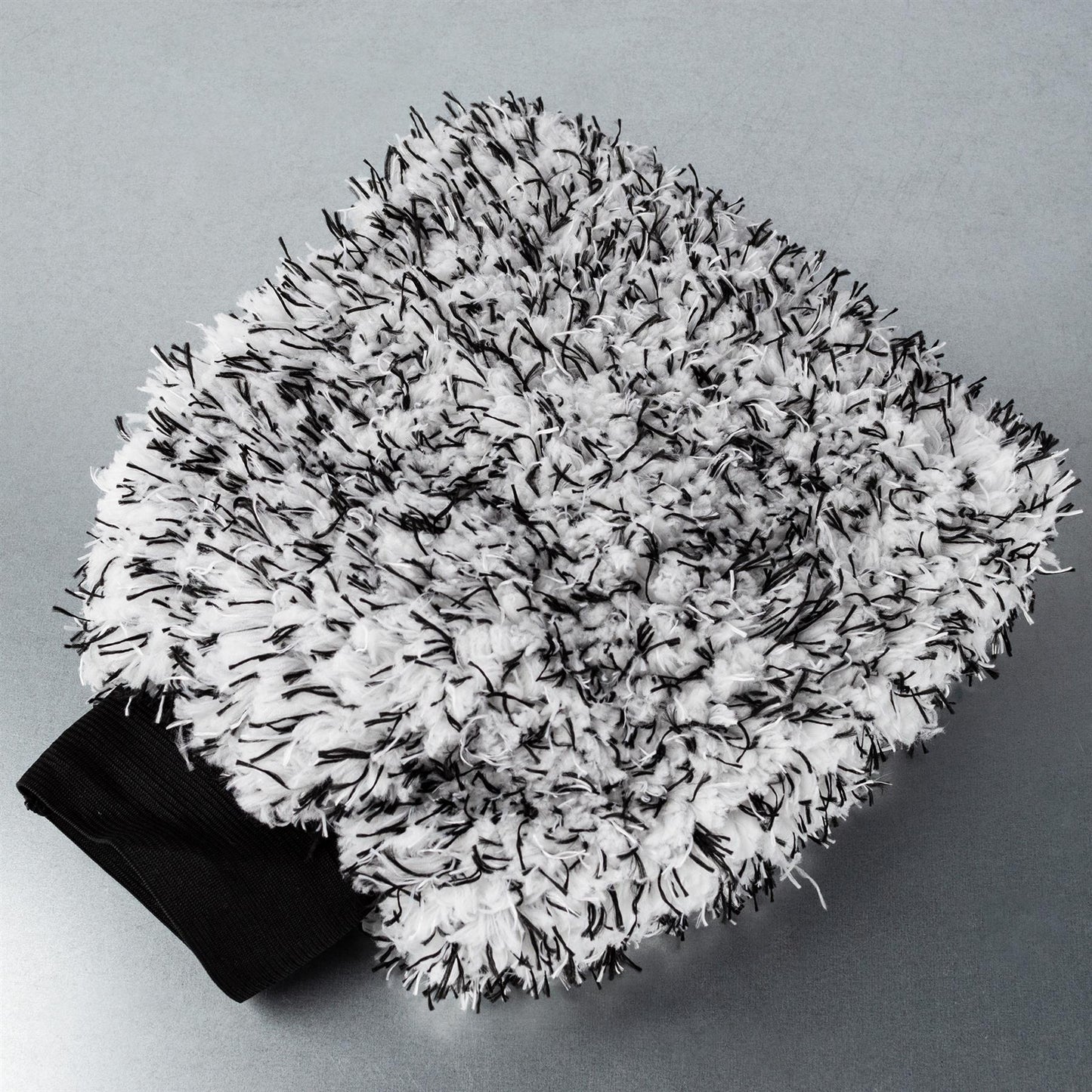 Fluffy microfibre car wash mitt with black and white strands. Soft, absorbent, and durable. Perfect car detailing accessory.