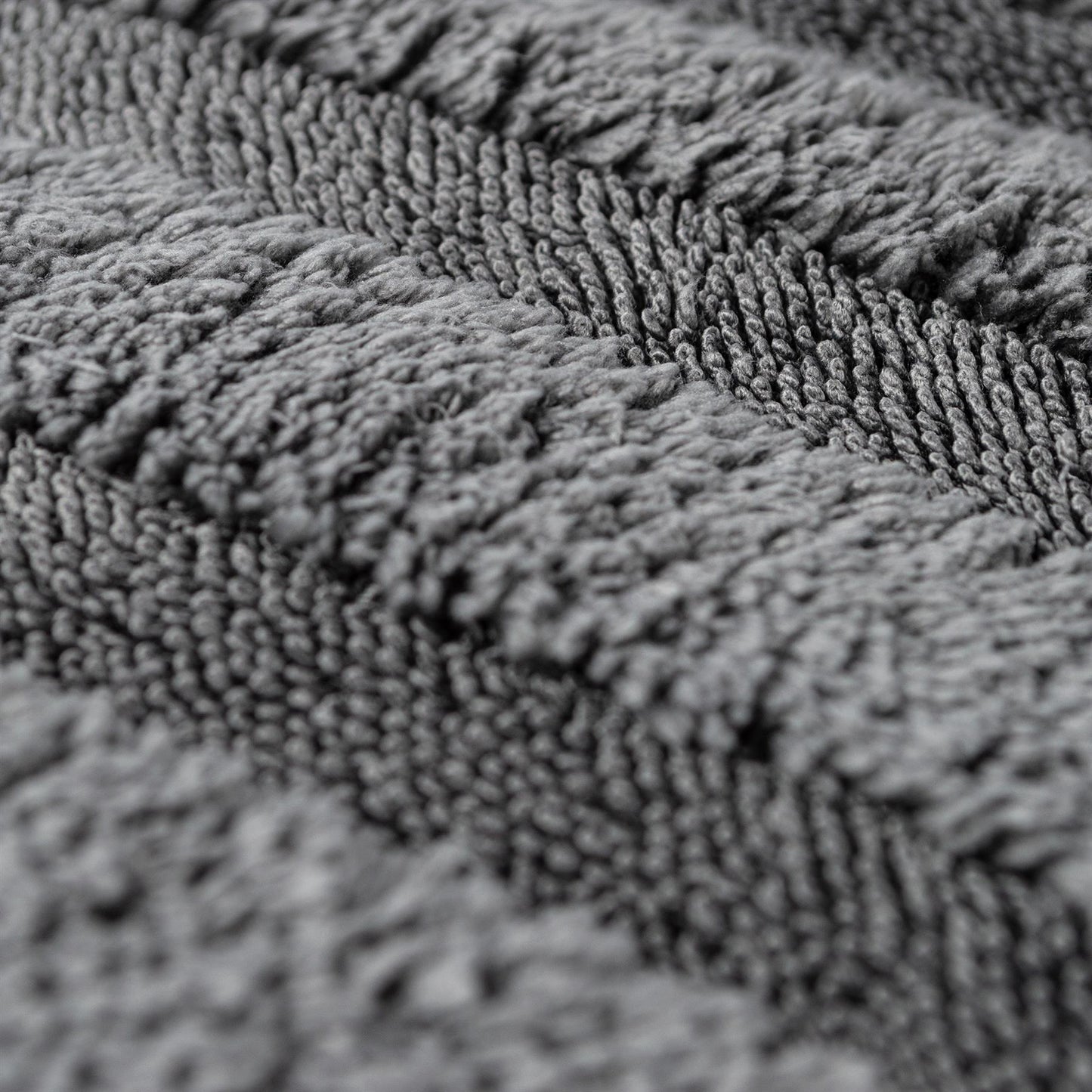Close-up of a grey microfiber cloth. Deep pile construction shown at an angle. Car detailing accessory.