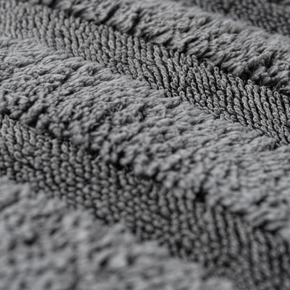Close-up of a grey microfiber cloth. Deep pile construction shown at an angle. Car detailing accessory.