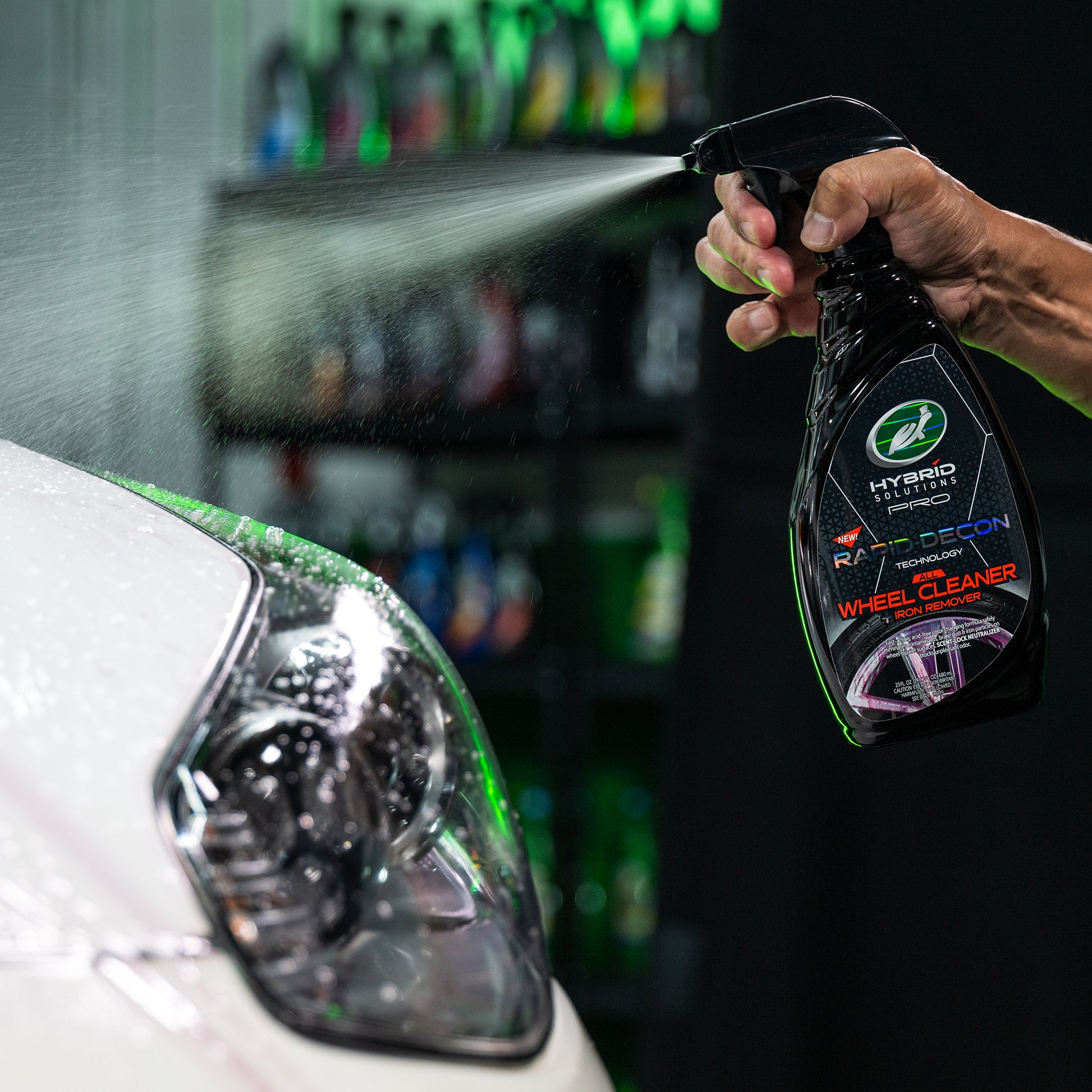 Turtle Wax Hybrid Solutions Pro wheel cleaner being sprayed onto a car. Iron remover and rapid decon technology.