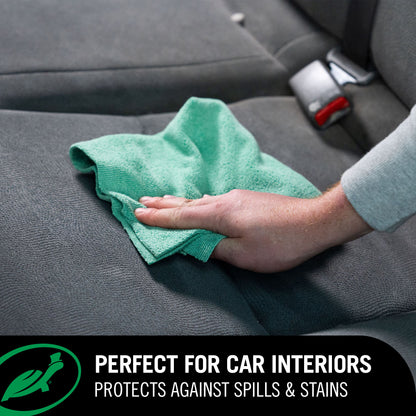 Hand cleaning a car seat with a green cloth, using Hybrid Solutions fabric protector