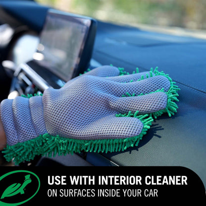 Gray cleaning glove with green bristles cleaning a car interior.