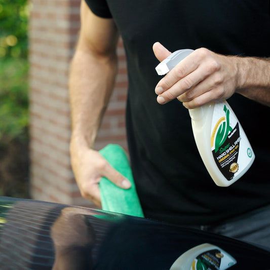 Man using Turtle Wax Super Hard Shell Finish Original Spray Wax (500ml) on a car. Detailing with green microfibre cloth.