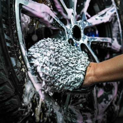Cleaning car wheels with a microfibre mitt and soapy water. Car detailing and valeting imagery.
