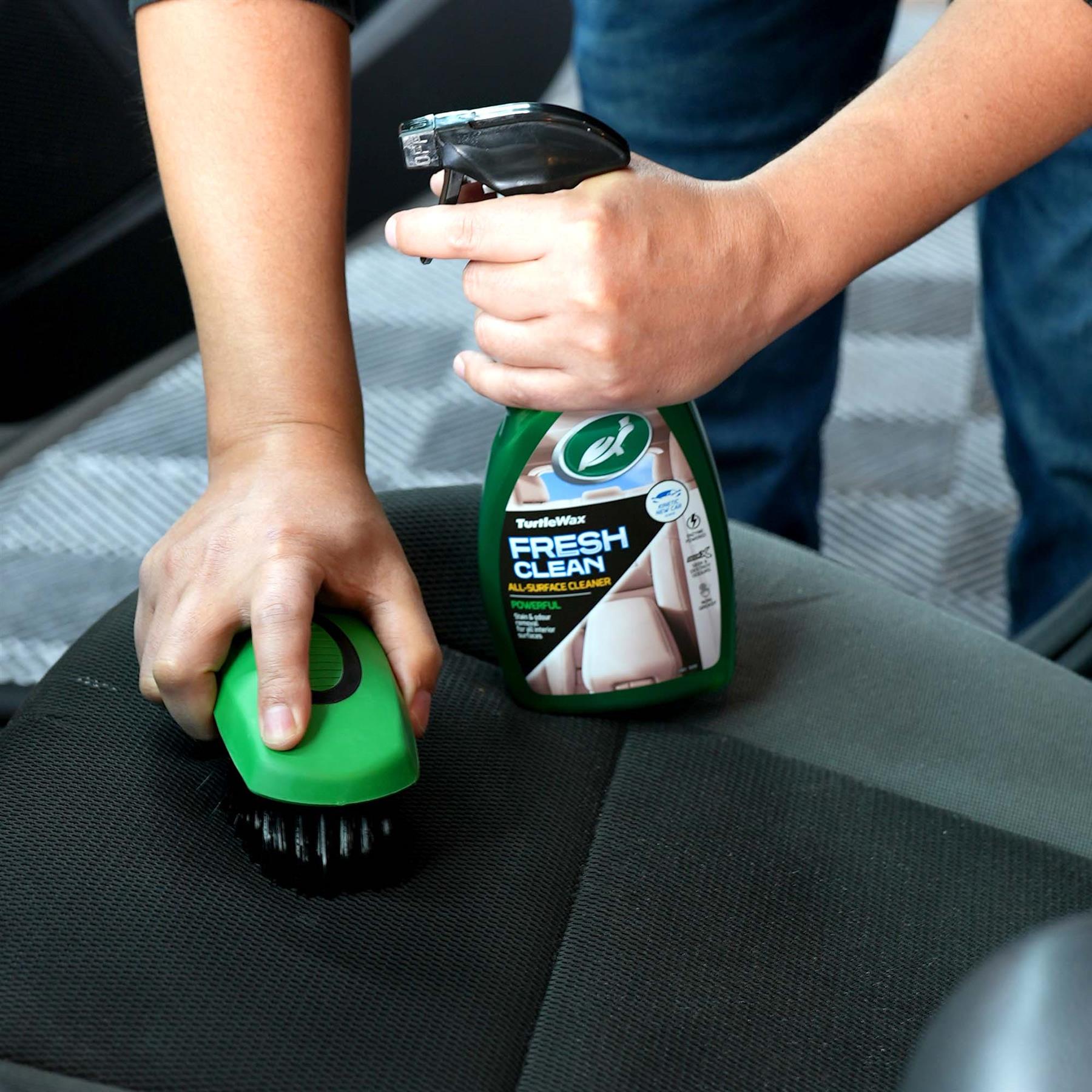 Fresh Clean Upholstery Reviver showing a man using the brush on his car seats 