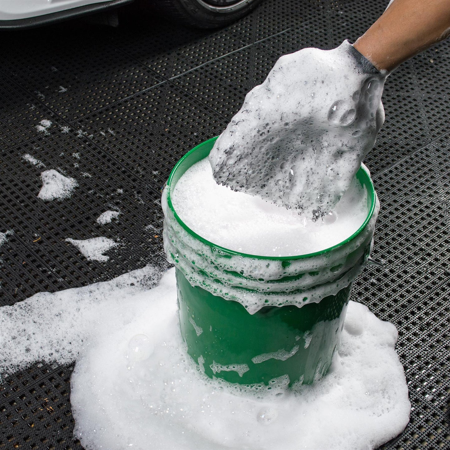 Microfibre wash mitt, shown covered in sudsy water beside a green bucket. Perfect for car valeting and automotive cleaning.
