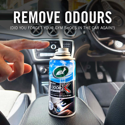 Can of Odor-X air freshener spray held by a hand inside a car, with text about removing odors.