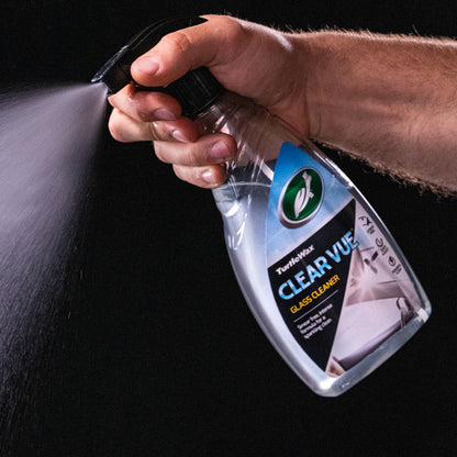 Hand spraying Turtle Wax Clear Vue Glass Cleaner. Car care product for a smear-free, intense clean.