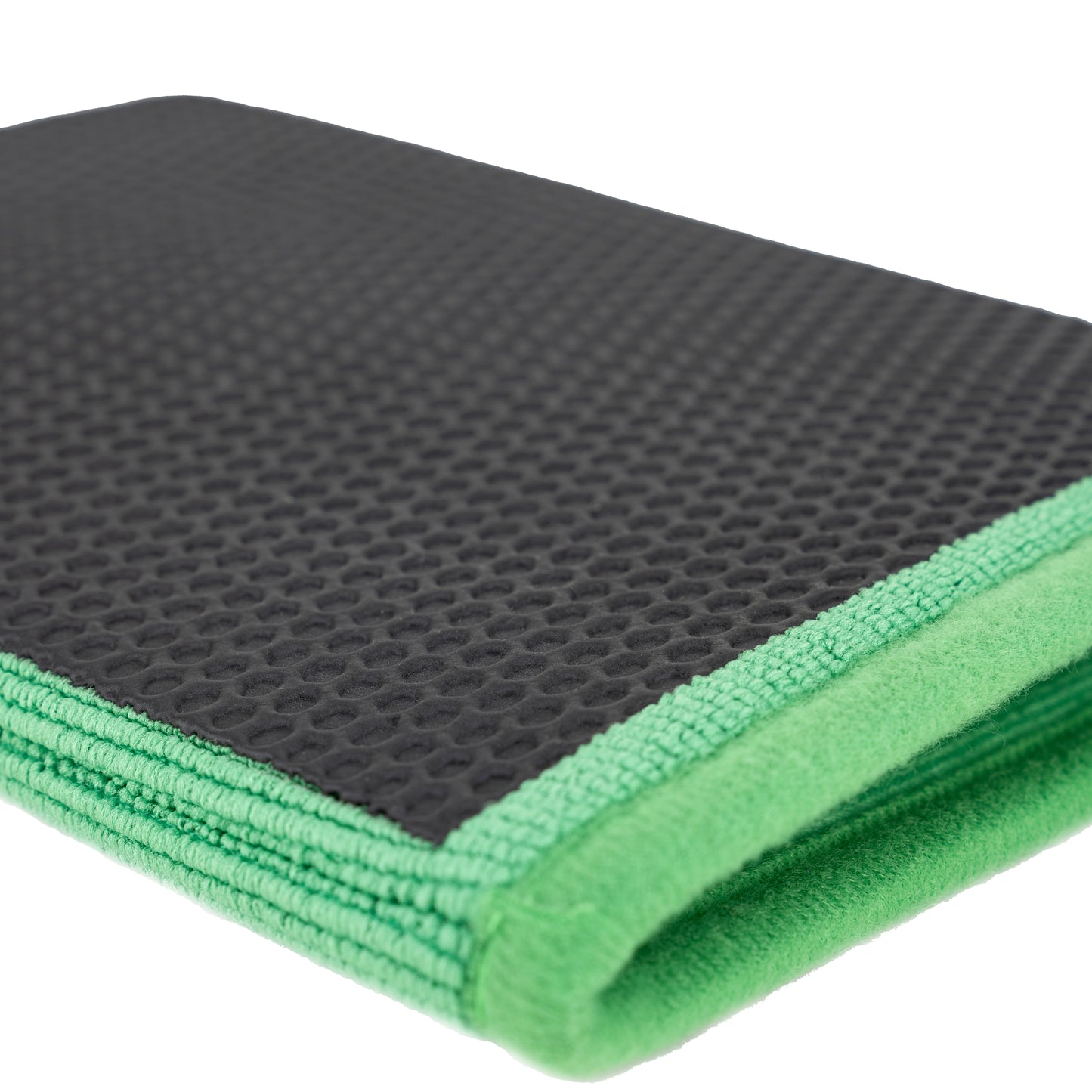 Black honeycomb patterned surface on top of a green microfibre clay mitt used for car detailing and valeting.
