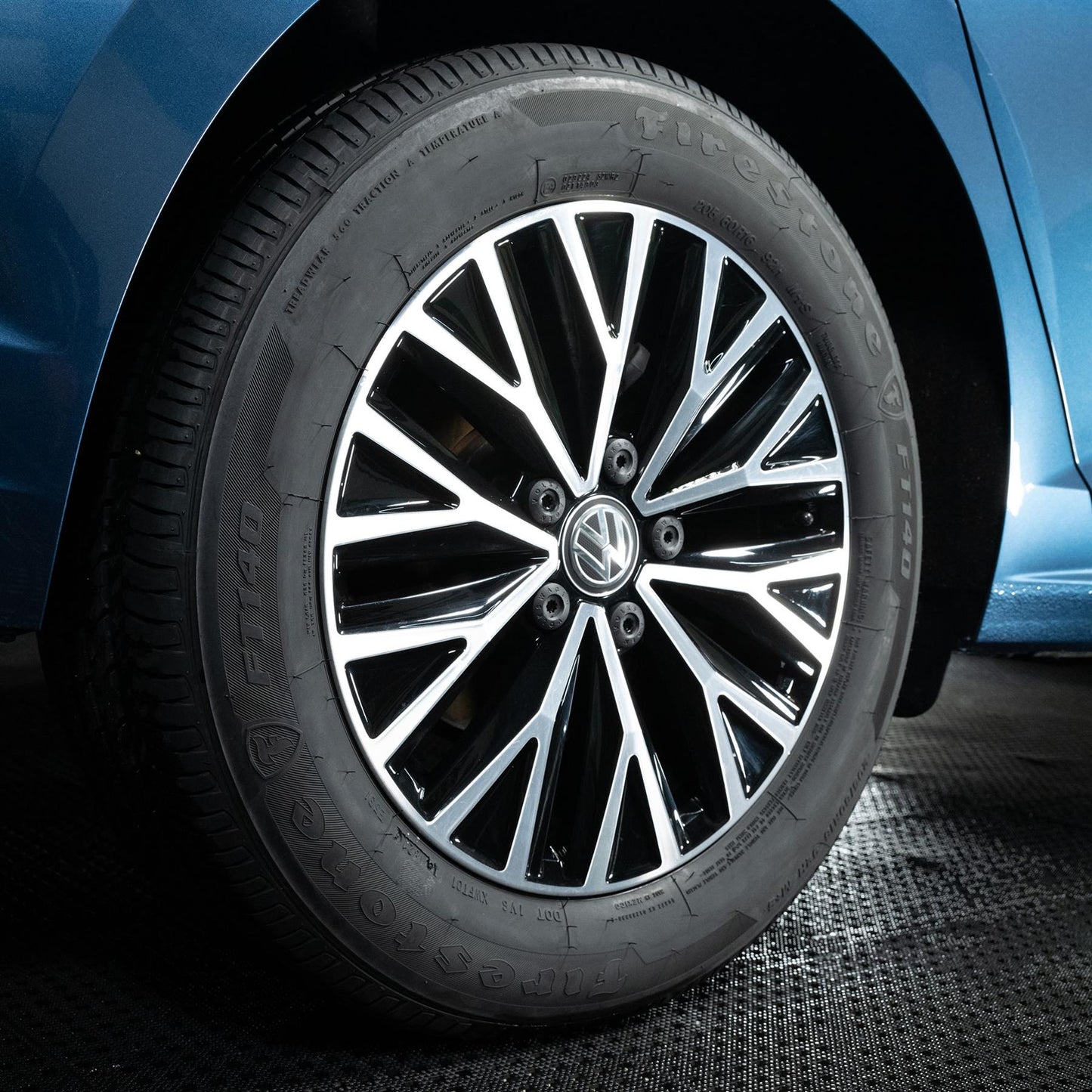 Close-up of a Volkswagen car wheel with a blue vehicle background