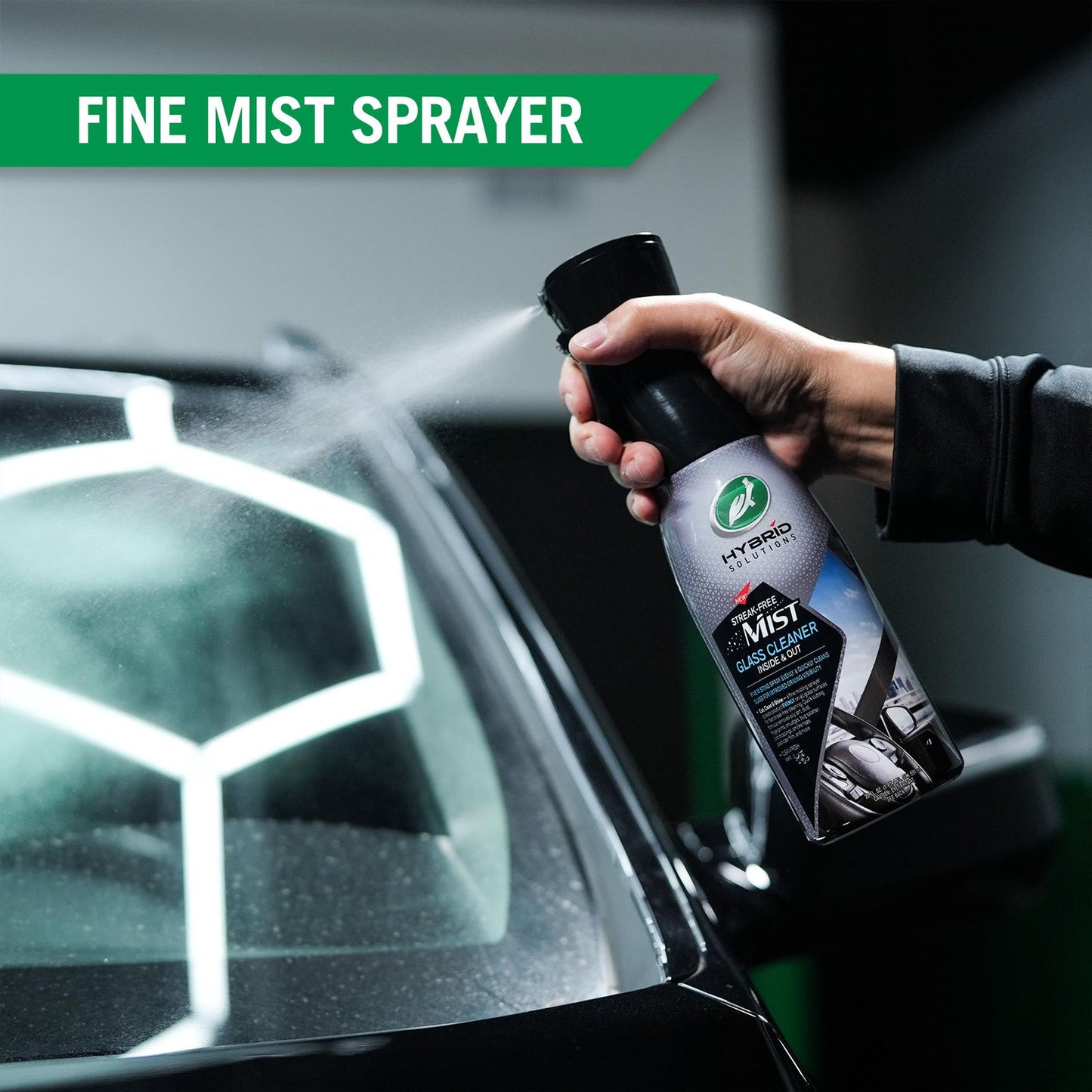 Turtle Wax glass cleaner being used, shown with fine mist. Streak-free product for improved visibility when driving.