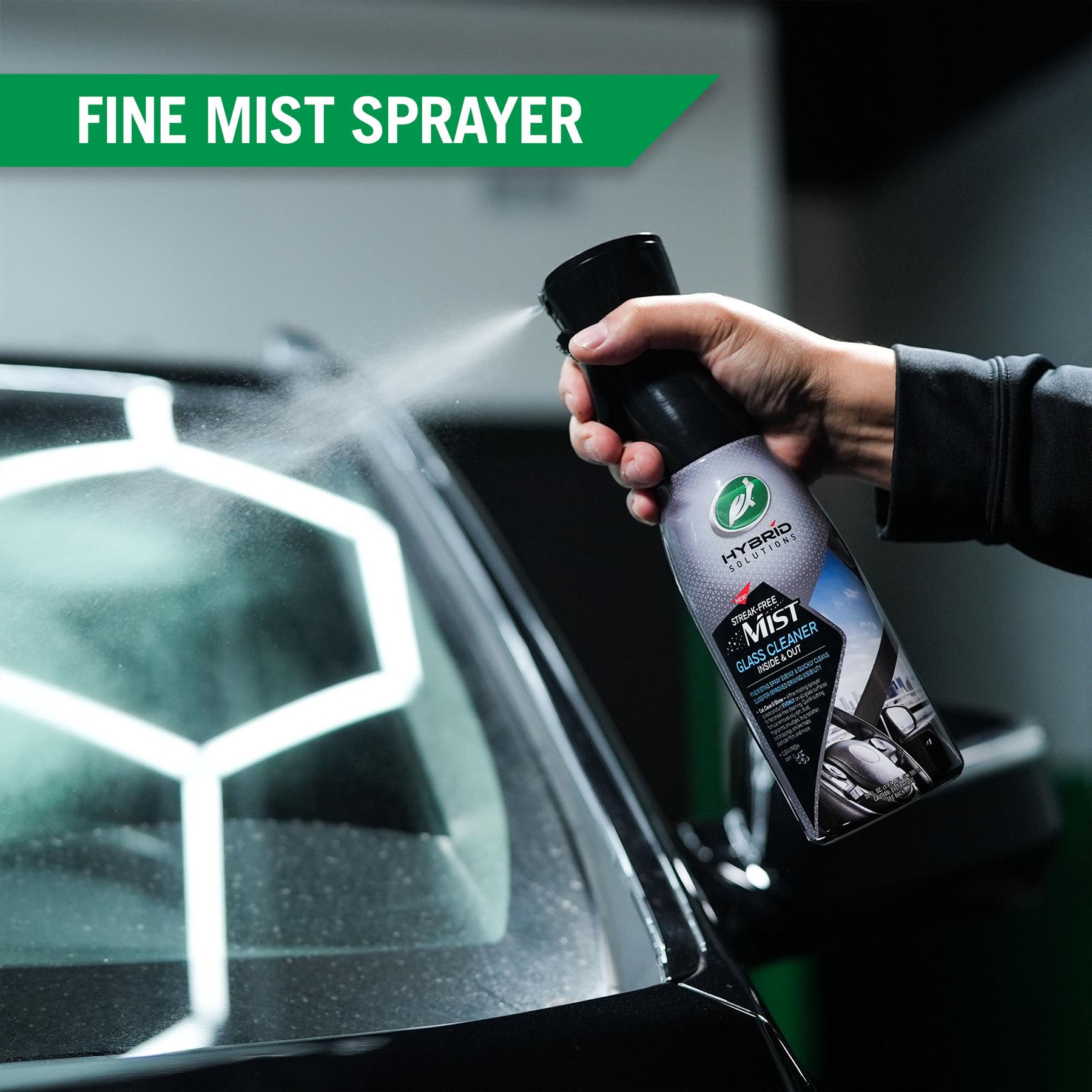 Turtle Wax glass cleaner being used, shown with fine mist. Streak-free product for improved visibility when driving.