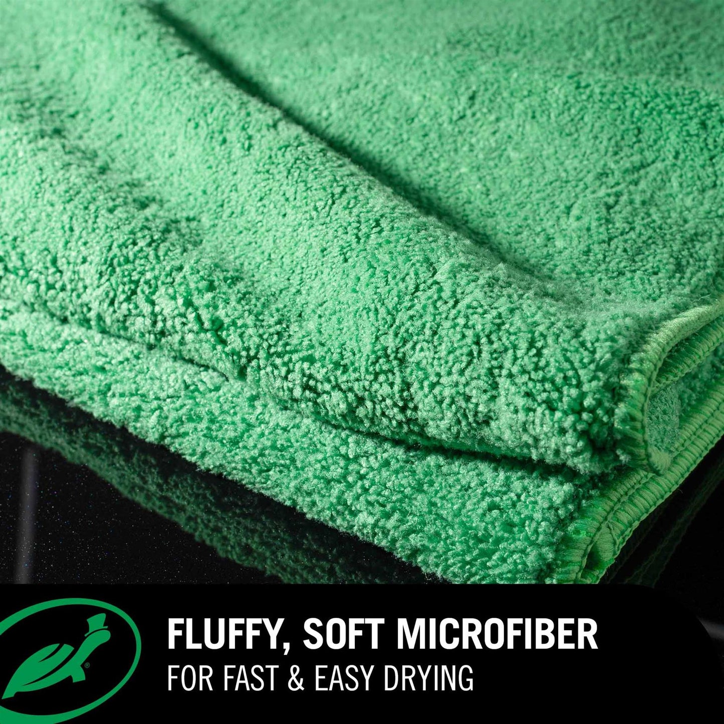 Green Jumbo Drying Towel with text highlighting its fluffy, soft microfiber properties on a black background