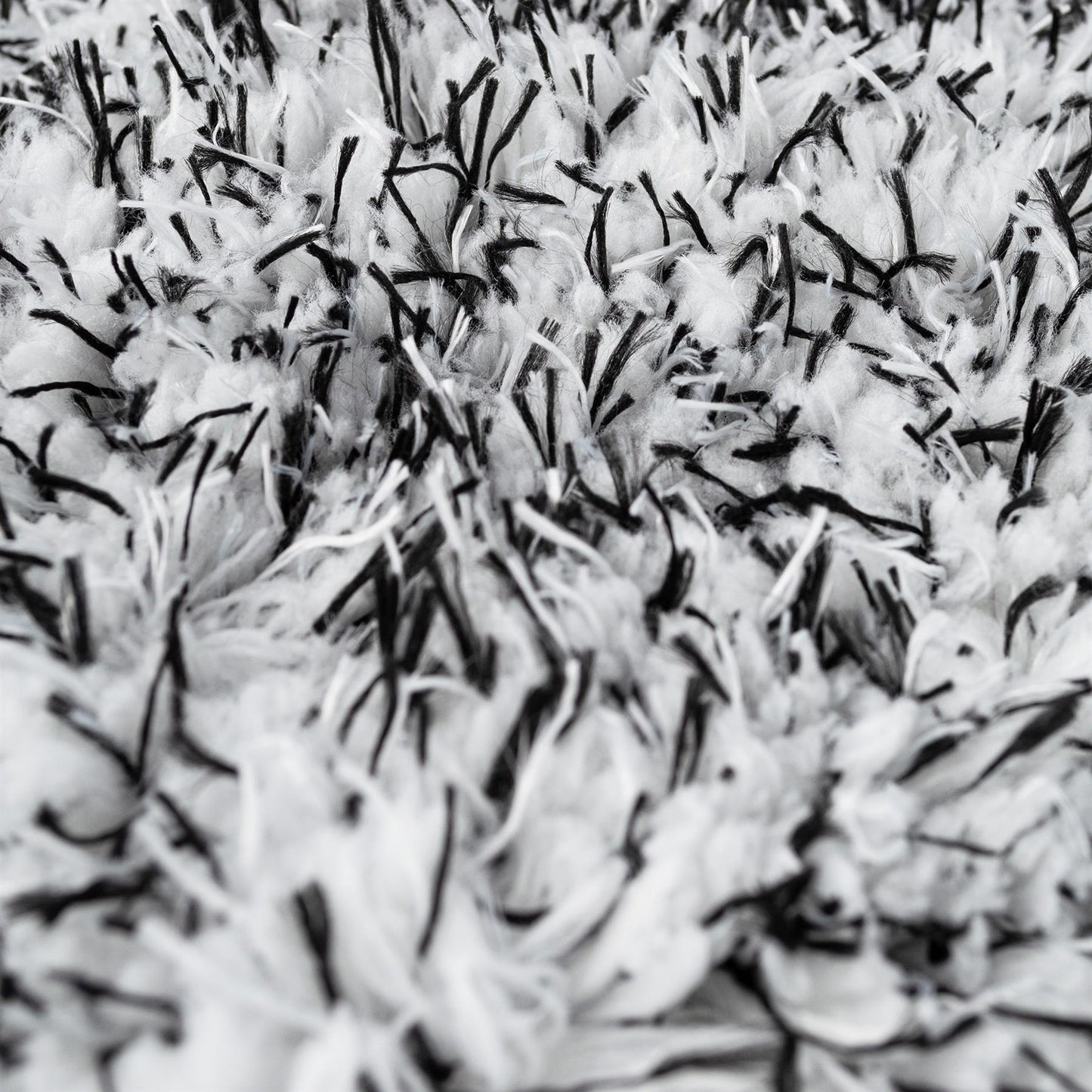 Close-up of a plush, high-pile cleaning mitt. Soft white microfibre with black detailing.
