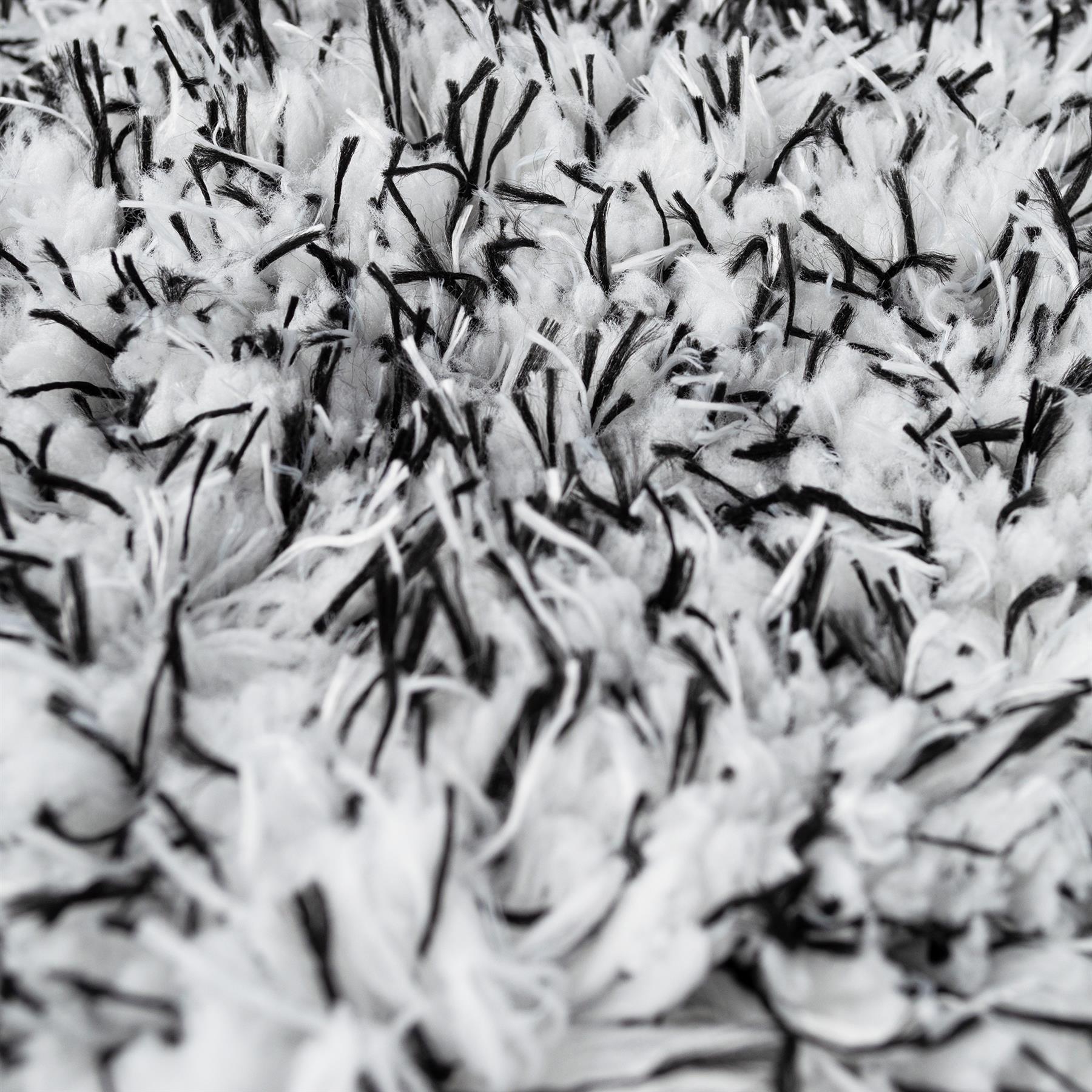 Close-up of a plush, high-pile cleaning mitt. Soft white microfibre with black detailing.
