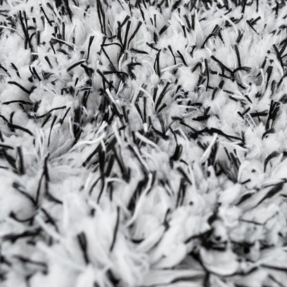 Close-up of a plush, high-pile cleaning mitt. Soft white microfibre with black detailing.
