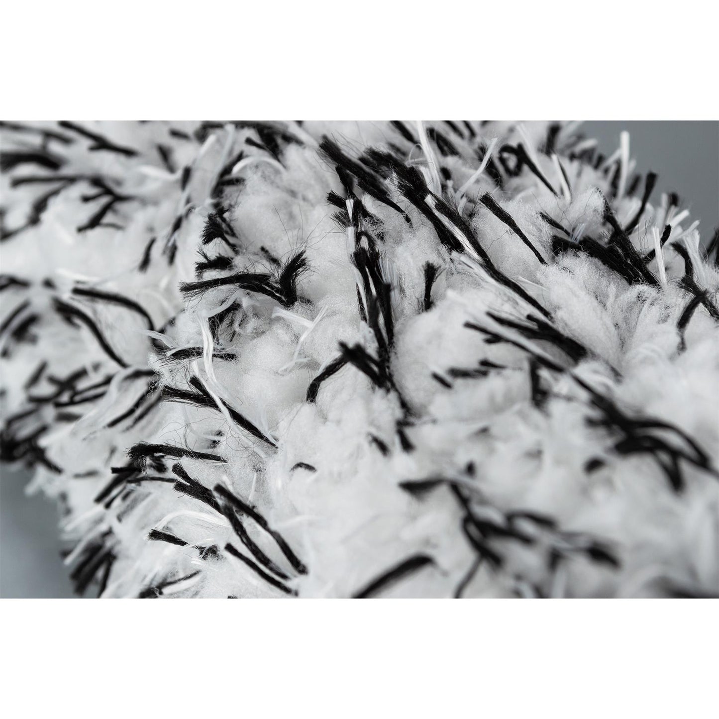 Close-up on a fluffy, white wheel cleaning brush with black filaments. Auto detailing equipment.