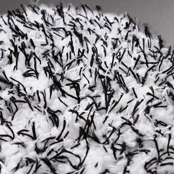 Close-up of a textured wash mitt. Features soft, white microfibre with contrasting dark detailing for car wheel cleaning.