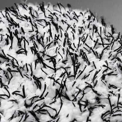 Close-up of a textured wash mitt. Features soft, white microfibre with contrasting dark detailing for car wheel cleaning.