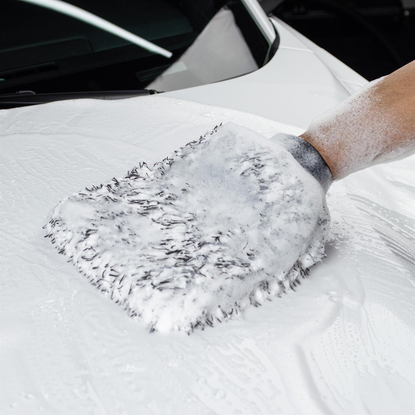 Microfibre wash mitt gently cleaning a motor car. Ideal for valeting & detailing. Super soft plush material for a streak-free finish.
