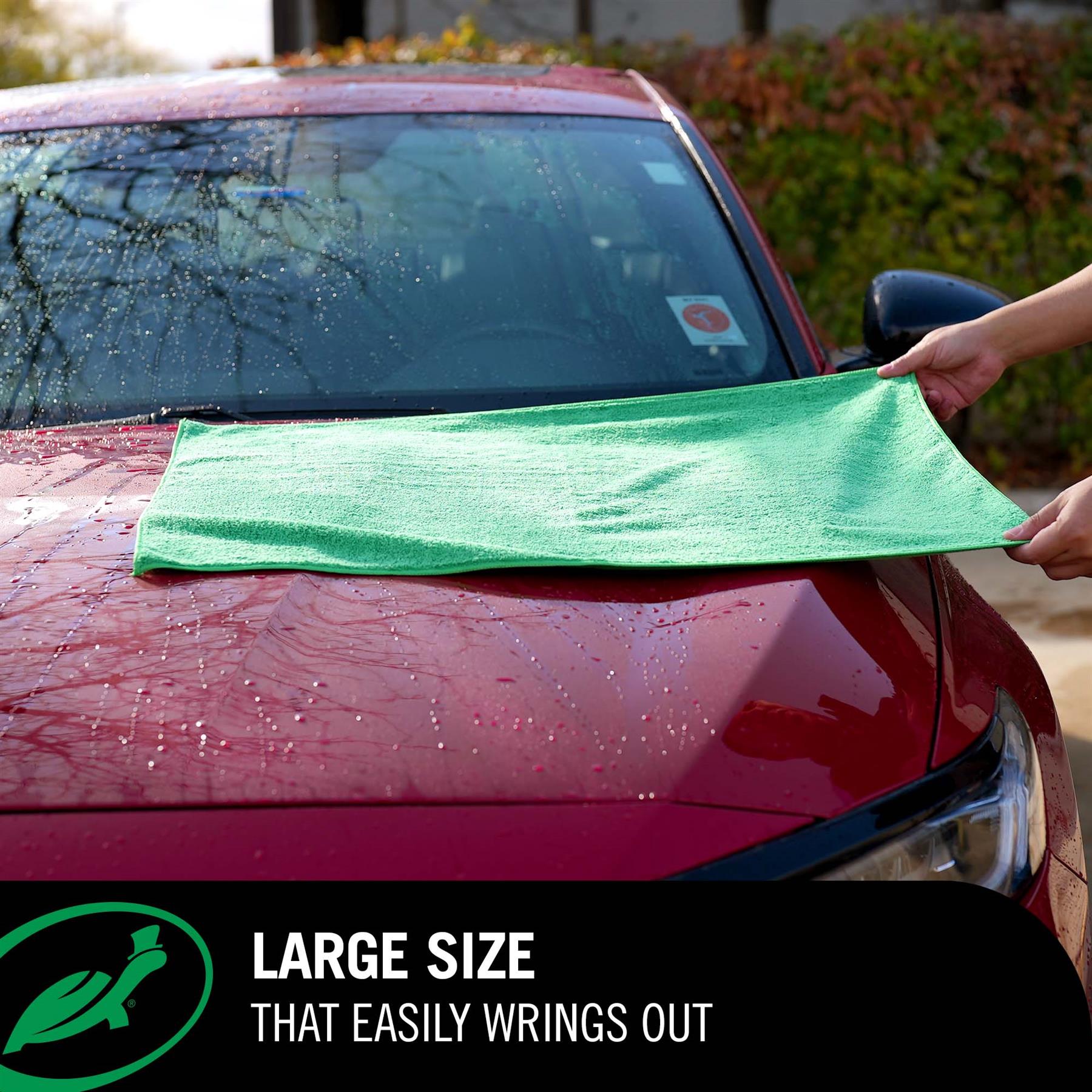 Person using a Green Jumbo Drying Towel on a red car with text about large size.