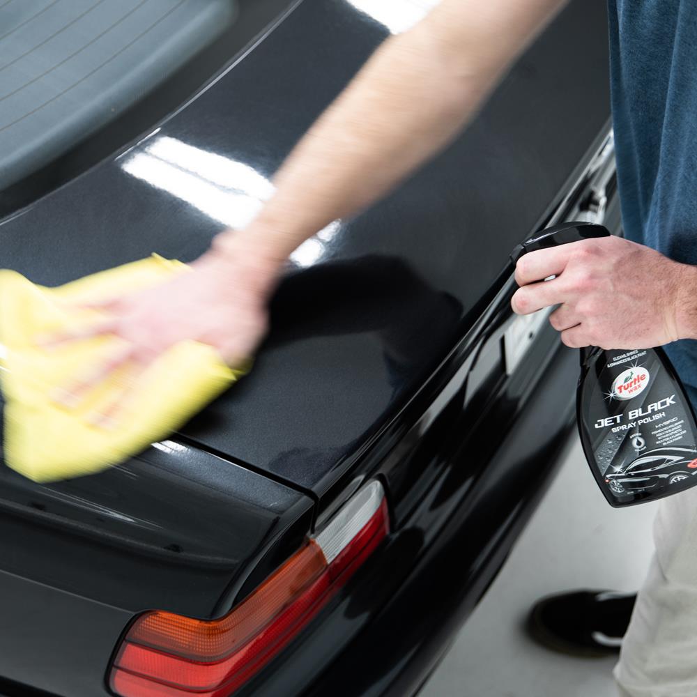 Black car being polished with Turtle Wax Jet Black spray polish. Car detailing for a glossy finish.

