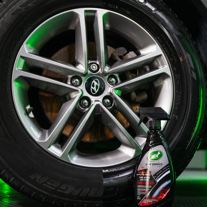 Turtle Wax Hybrid Solutions spray bottle beside a shiny tyre and alloy wheel. Graphene Acrylic provides deep, dark gloss and UV protection.