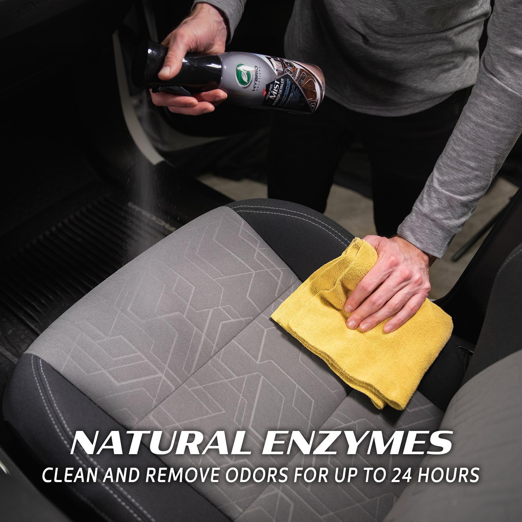 Car seat detailing. Person sprays interior cleaner and wipes the surface with a yellow microfibre cloth. Turtle Wax visible on spray bottle.