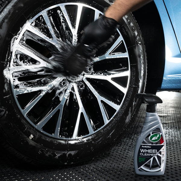 Close-up on product and car wheel spokes as cleaner is applied.