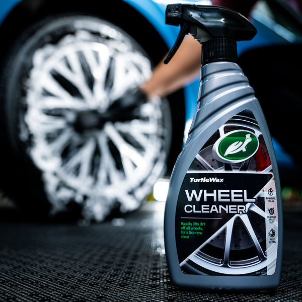 Product lying on tire with reflection highlighting bottle design.