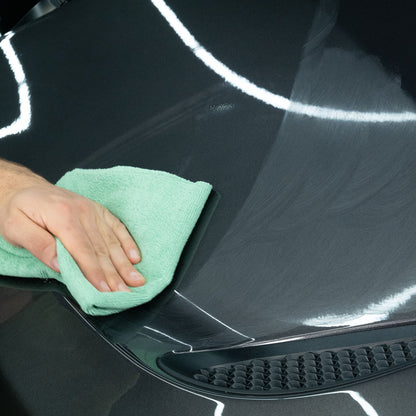 Polishing car paintwork. Hand buffs vehicle's bonnet with a microfibre cloth, removing swirl marks. Car detailing. Turtle Wax.
