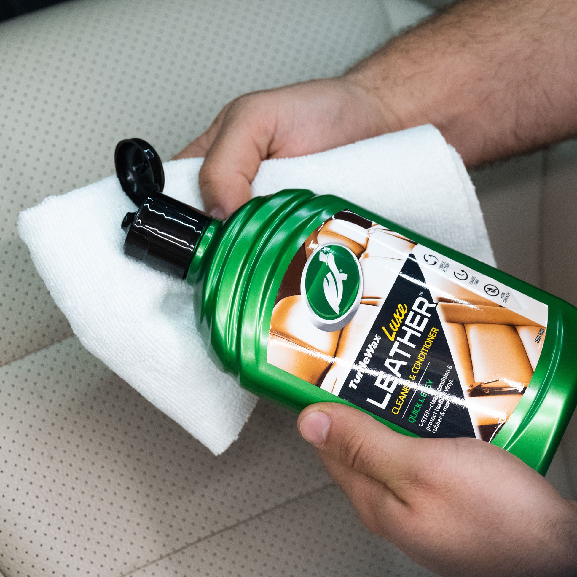 Turtle Wax Luxe Leather cleaner being applied to a soft cloth. Ideal for car interior detailing and protecting leather surfaces.
