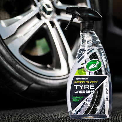 Turtle Wax Wet'n Black tyre dressing spray next to a car tyre. Creates a deep, wet-look shine for your vehicle's tyres.