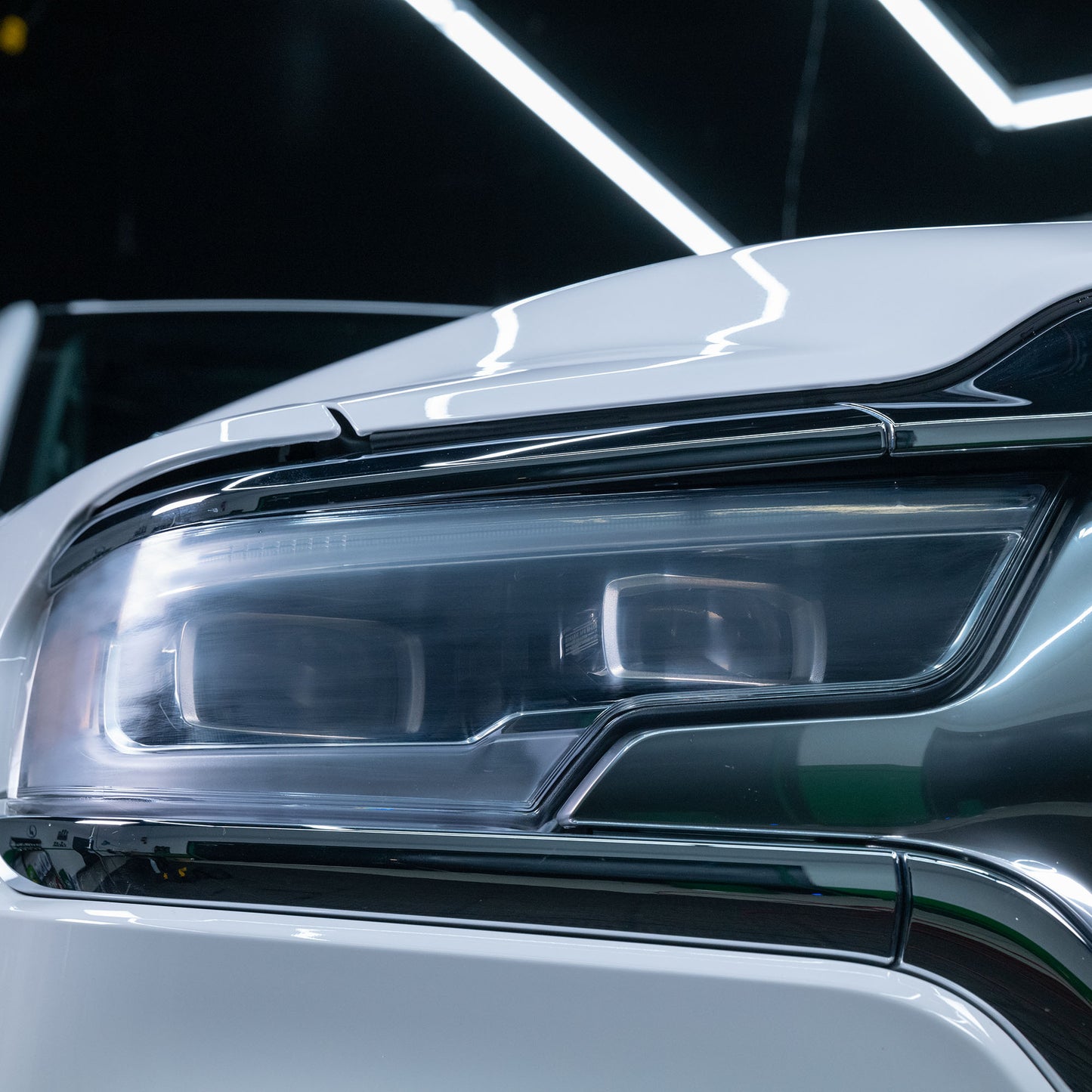 Bright, modern car headlight, showcasing clarity after automotive lens restoration. The light shines brilliantly.