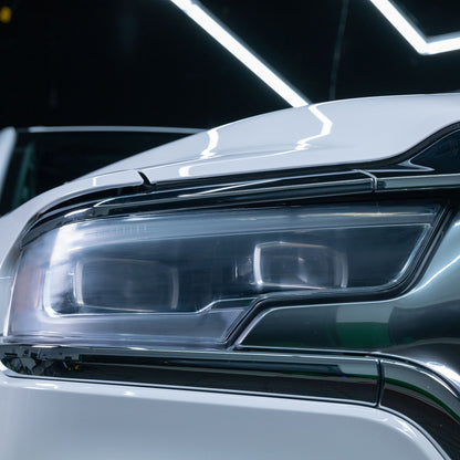 Bright, modern car headlight, showcasing clarity after automotive lens restoration. The light shines brilliantly.