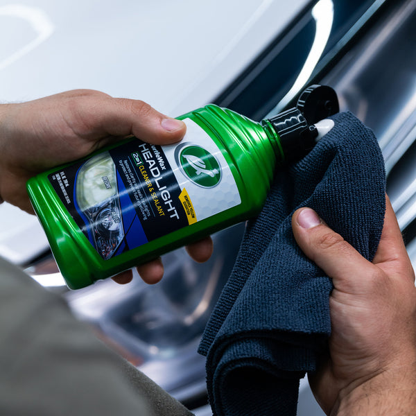 Headlight lens halfway cleaned with Turtle Wax Headlight Cleaner & Sealant, showing stark contrast between cloudy and clear areas.