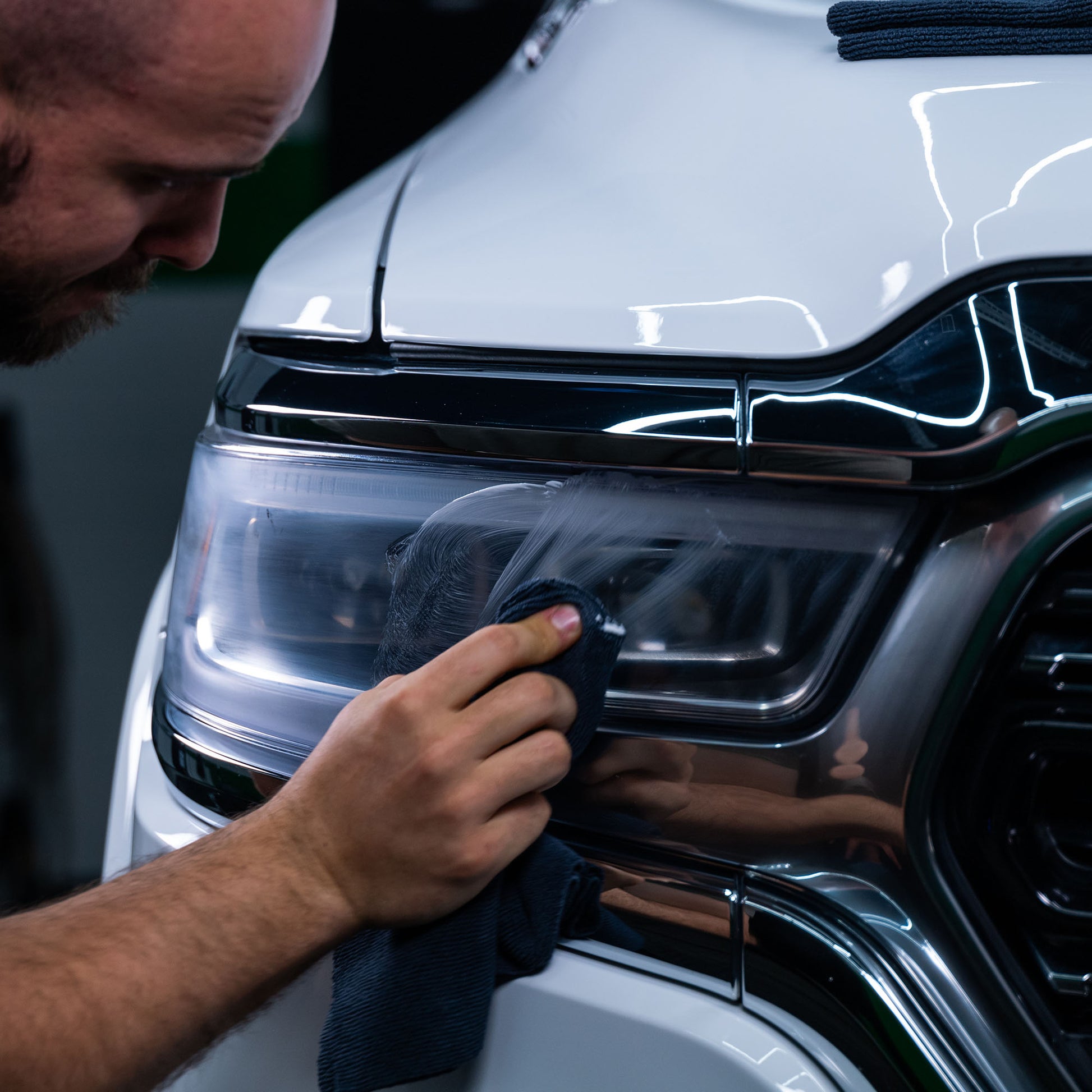 Detailing a car headlight. Application of Turtle Wax headlight restorer for clarity. Car care and valeting.