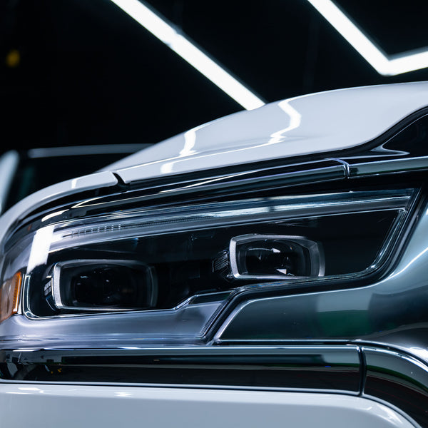 Image comparing left and right headlights â€” one treated with Turtle Wax Headlight Cleaner and one untreated â€” to showcase product effectiveness.