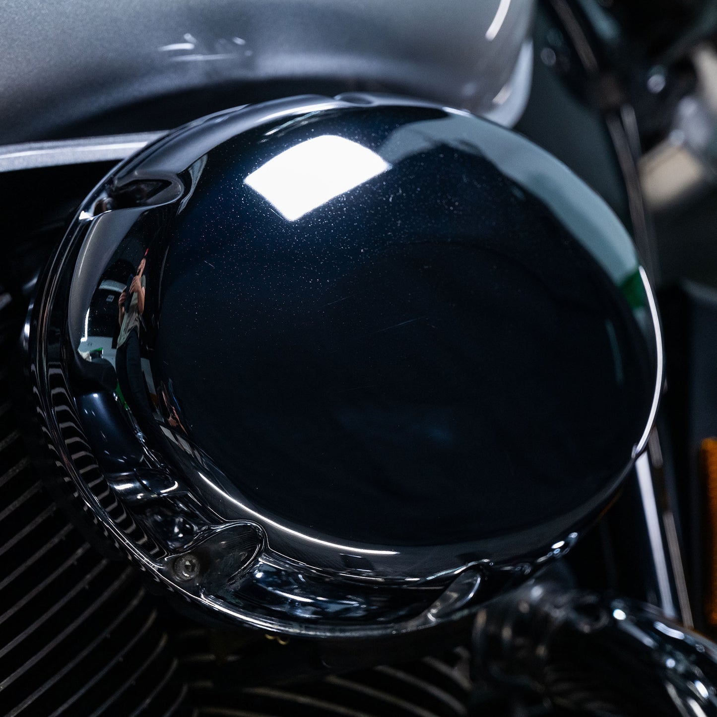 Chrome motorcycle part with reflection. Metal care product may help keep it sparkling.