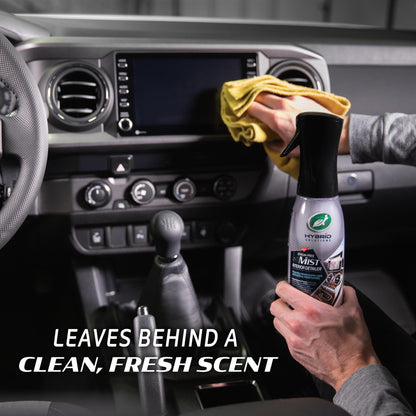 A man cleans a car dashboard with a Turtle Wax Hybrid Solutions detailer and cloth. Interior auto detailing.
