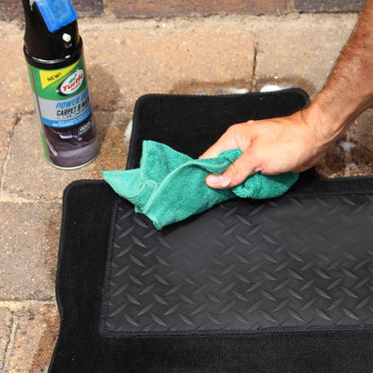 Cleaning vehicle floor mats. Applying Turtle Wax product with a cloth. Auto detailing.